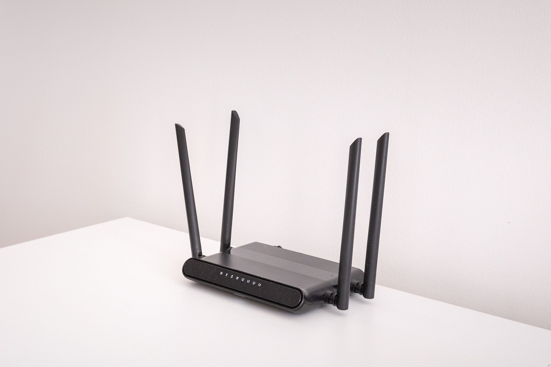 black wifi router on white table indoors
